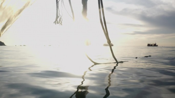 一艘船的锚绳，夕阳在海上的背景