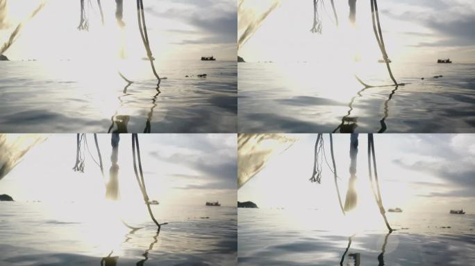 一艘船的锚绳，夕阳在海上的背景