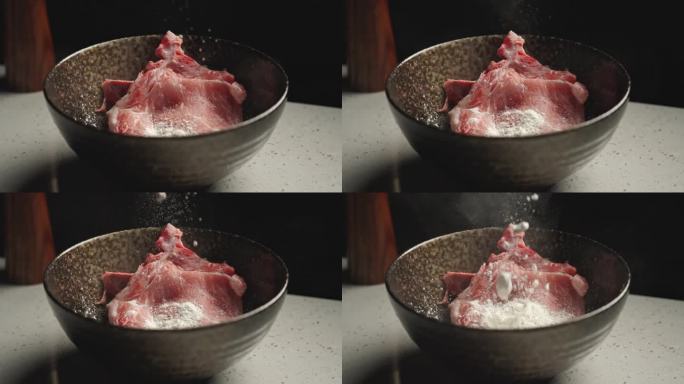 在碗中的猪肉上加入淀粉腌制