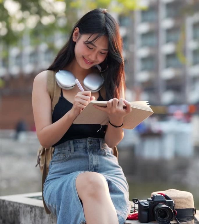 一名亚洲女游客在泰国北部省份的一个旅游景点用日记放松