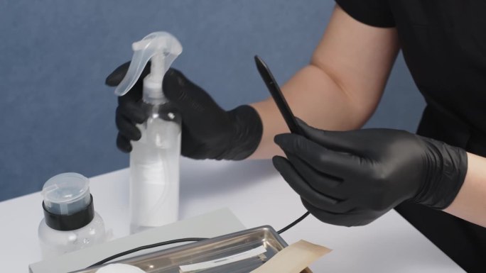 在美容院，戴着黑色手套的美容师正在准备电解针。电动脱毛器。仪表板。脱毛装置。