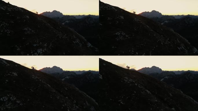 空中拥抱大自然的辉煌:徒步旅行者陶醉在黄昏的山脉威严