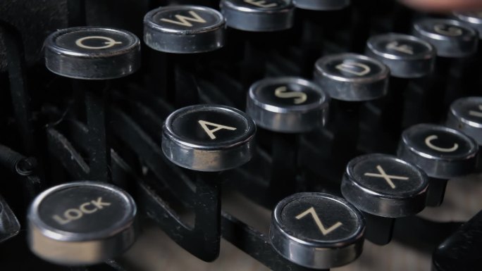 操作一台20世纪20年代的老式打字机，按下键盘命令罢工者并制作一份文件。选定字母的角度特写细节镜头。