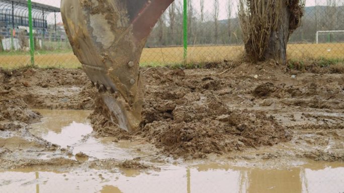 建筑工地工业挖掘机从道路洪水中挖泥