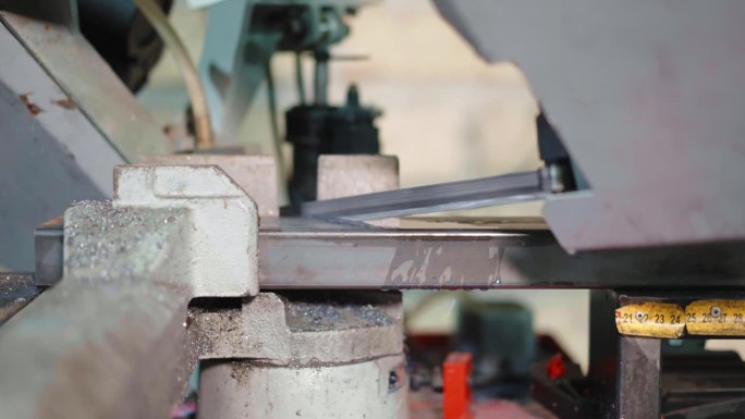 在工业工厂从事与金属相关的工作，在车间使用带有锋利锯和水冷却系统的自动切割机，用旋转运动和压力切割金