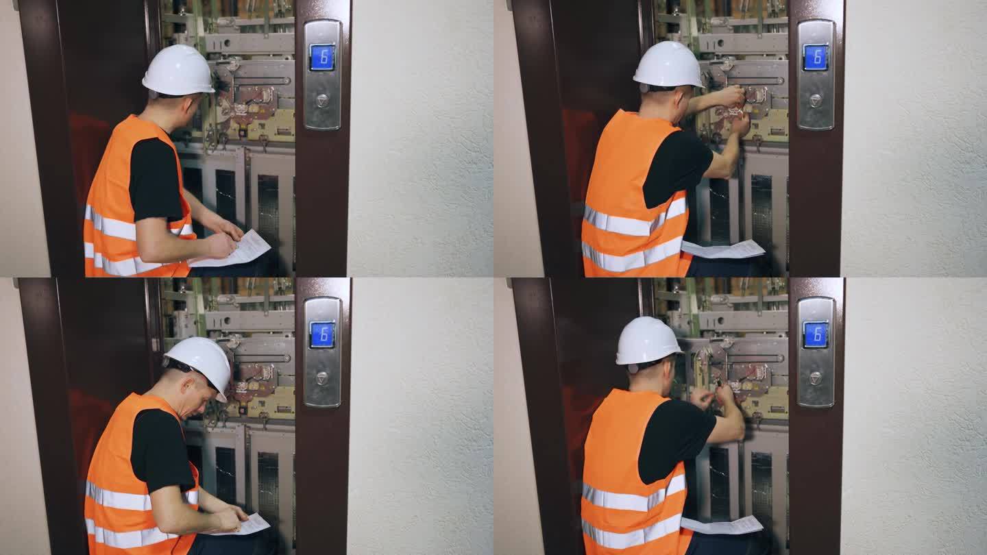 一名男性公用事业工人在住宅楼检查电梯的运行情况。电梯出故障了;一个公用事业公司的员工正在修理电梯。