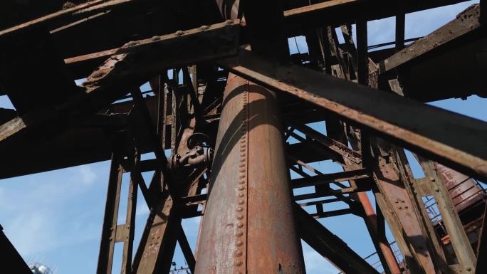 旧工业结构的复杂，生锈的外观，以纵横交错的金属梁包围的大型圆柱形管道为特色