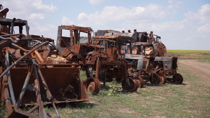 生锈的农业机械被遗弃在田野里。战争后果的概念。
