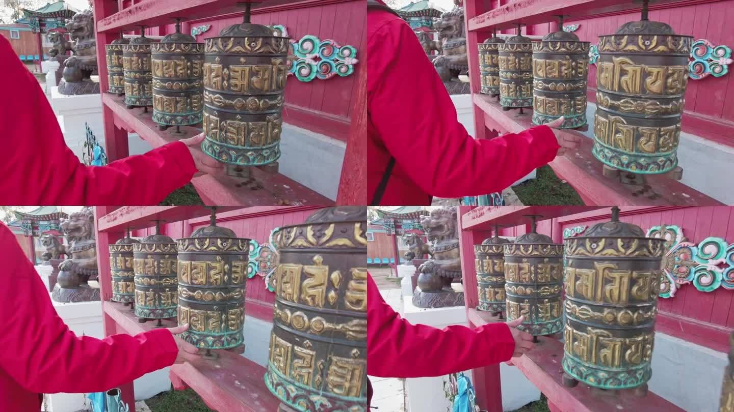 2021年9月7日，俄罗斯伊沃尔金斯克:古老的佛教经轮特写。男人的手一个接一个地旋转着祈祷鼓。慢镜头