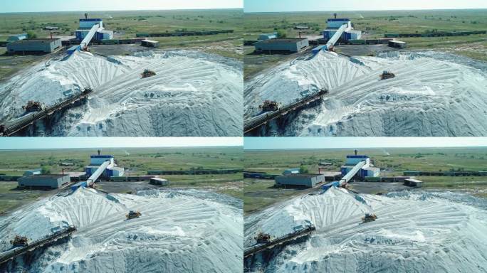 俄罗斯阿尔泰地区盐厂大堆盐的天线。跟踪器在桩上行驶。重型工业设备
