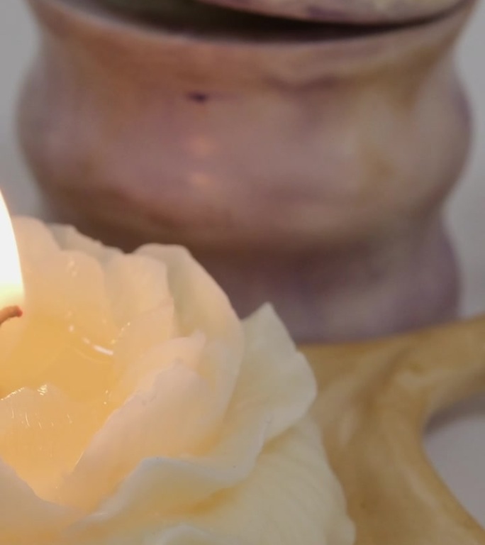 剪下香氛蜡烛，女人在家里做蜡烛，女性的手从锅里倒黄色的液体蜡到硅模里