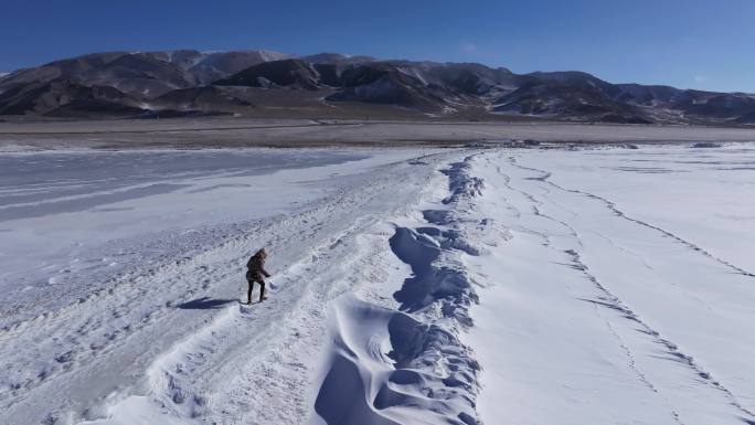 女孩在新疆赛里木湖白雪覆盖的湖面上行走