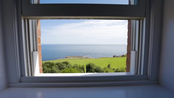 海景从小屋窗户在迷人的英国海岸