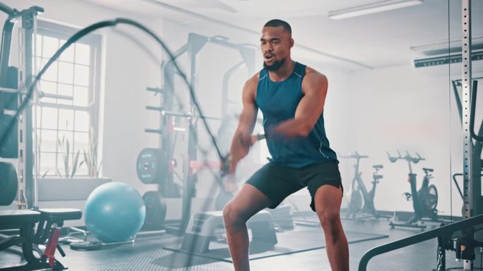 健身房、健身室和黑人男子用战绳波进行肌肉生长、力量发展和力量锻炼。装备、耐力和非洲健美运动员在锻炼、