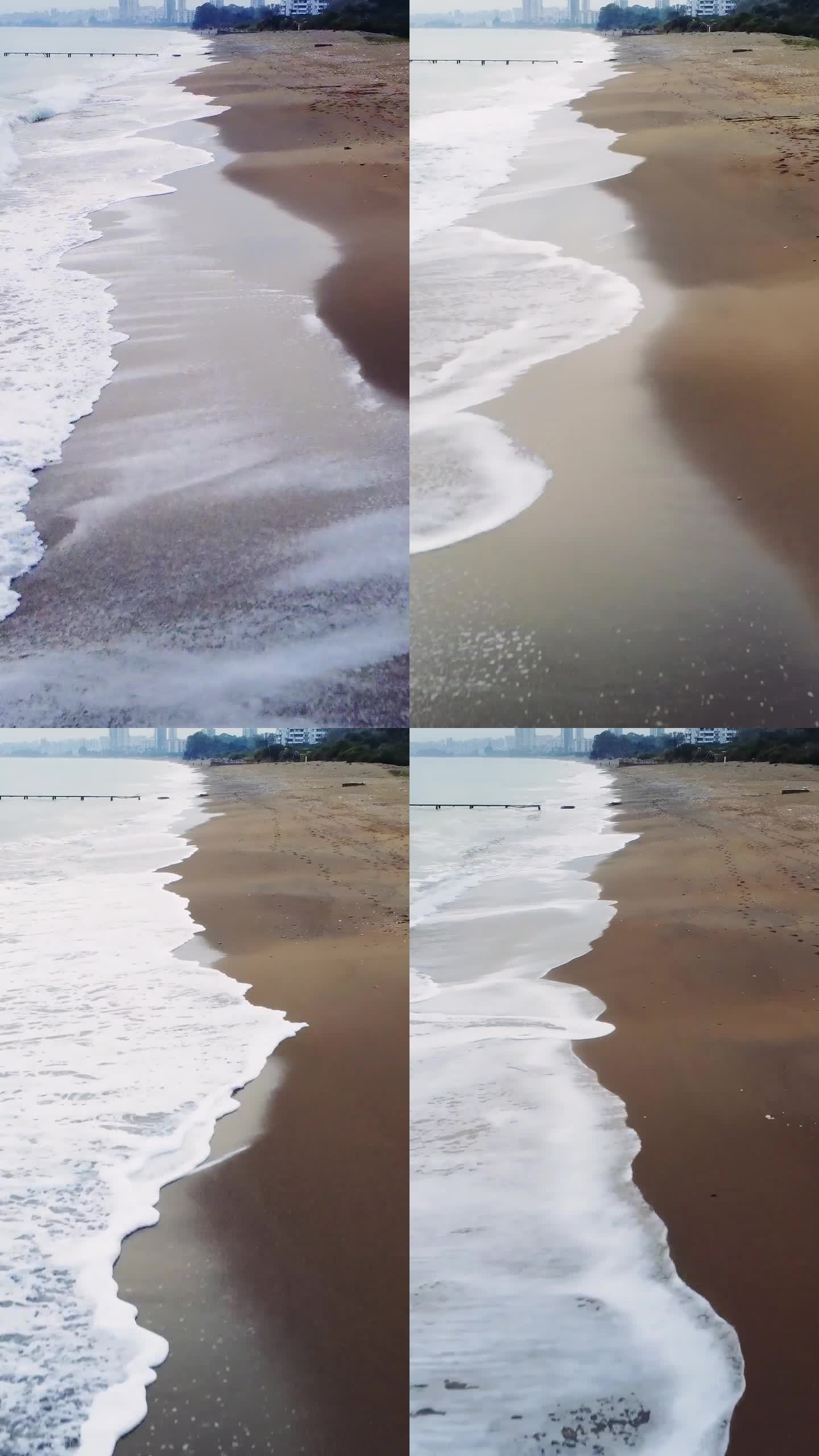 低空无人机沿着沙滩的冲浪线飞行。海岸线一直延伸到地平线，海浪拍打着海岸。在这宁静的景色中探索海洋和海