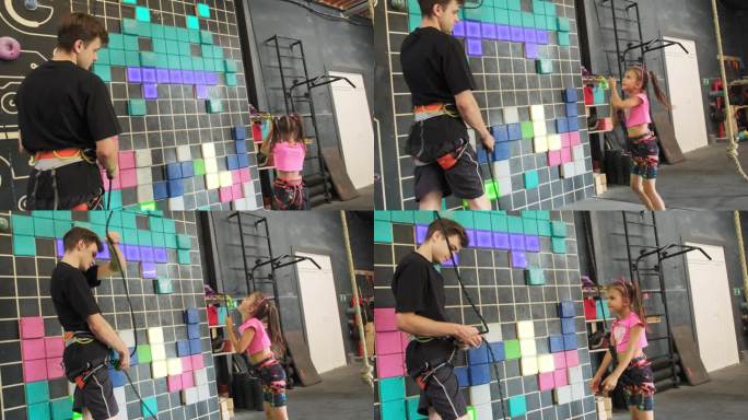 男子用心地帮助孩子爬下攀岩墙