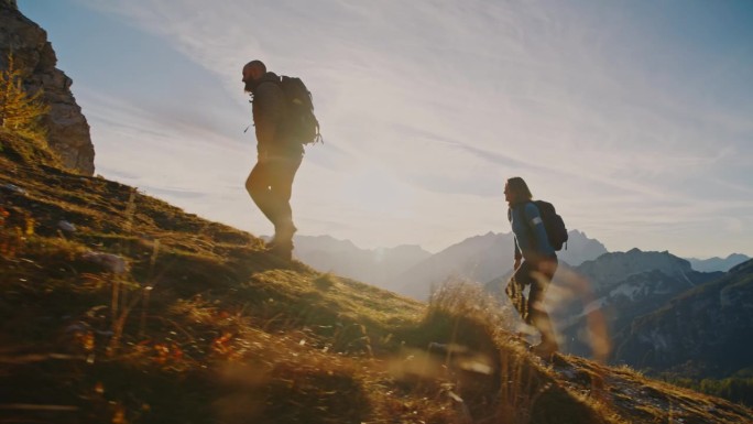 一起攀登:一对夫妇在日落时分征服高山