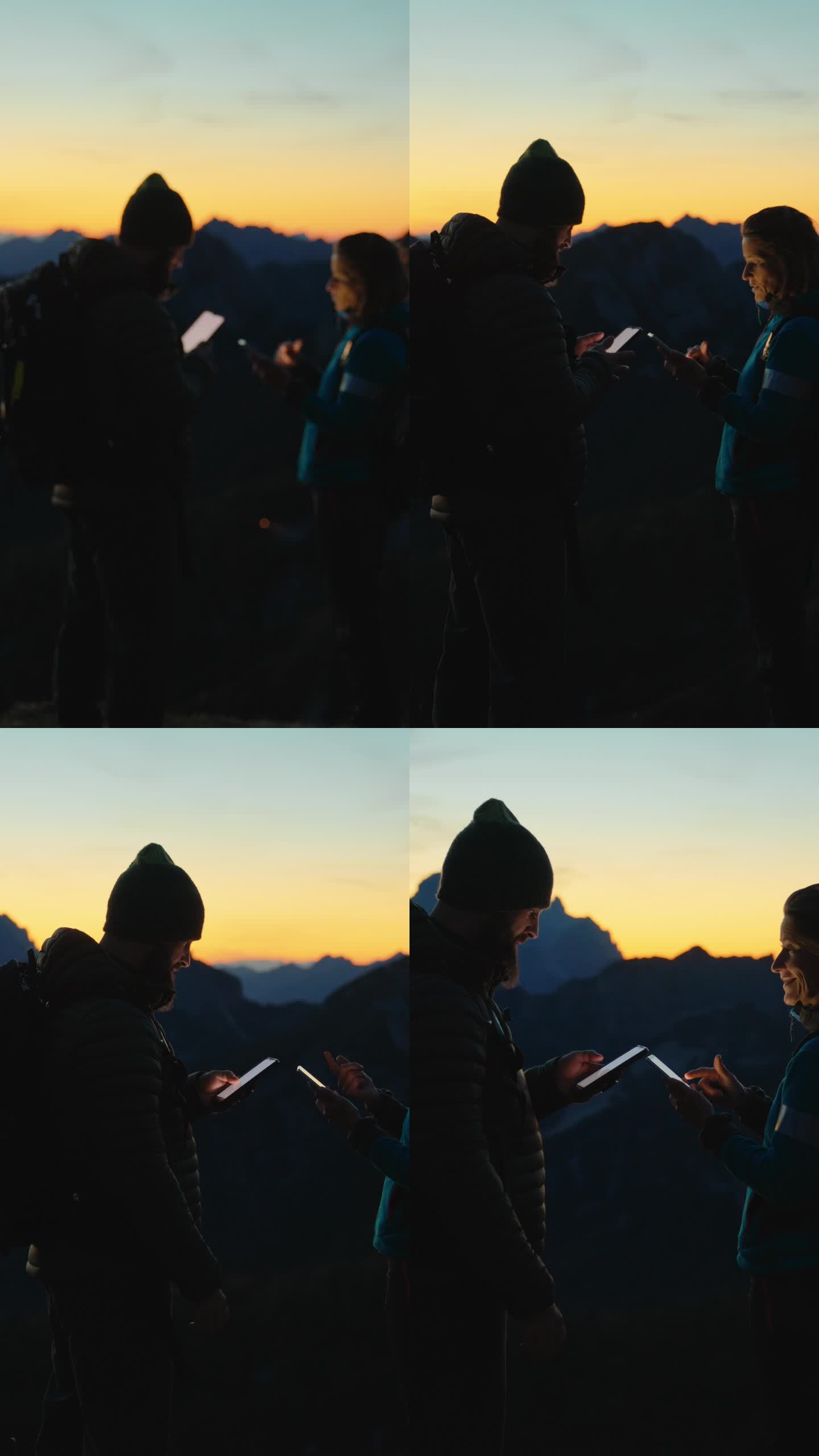 SLO MO在数字领域的导航:黄昏时分，爱冒险的夫妇在山顶上使用技术