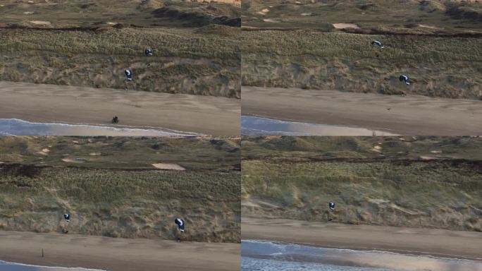 无人机拍摄的一对滑翔伞在荷兰Wijk Aan Zee的沙滩上翱翔