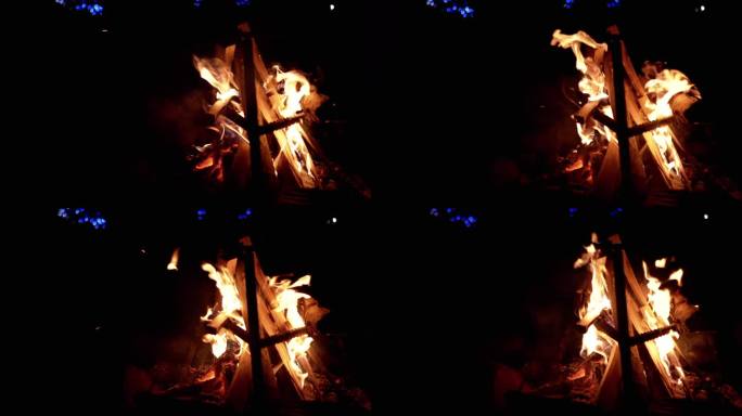 黑色背景下暗夜森林中燃烧的营火