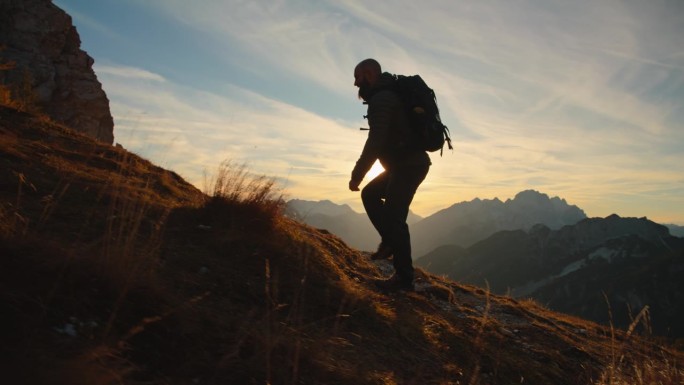 攀登高峰:男性徒步旅行者探索长满草的山路