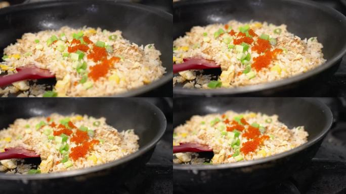 在炉子上的热锅里，把芥末洒在葱花蟹炒饭上，近距离慢镜头4K