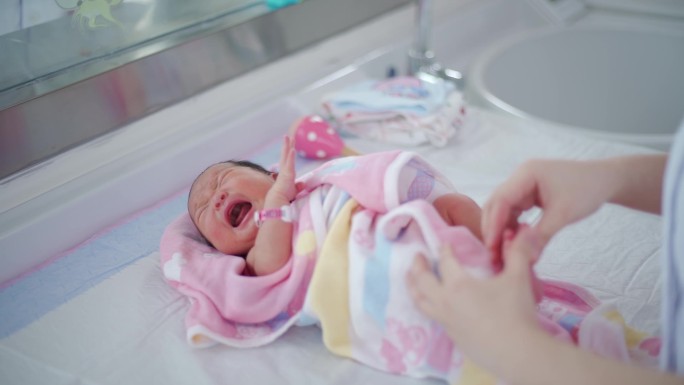 护士牵着新生婴儿的手
