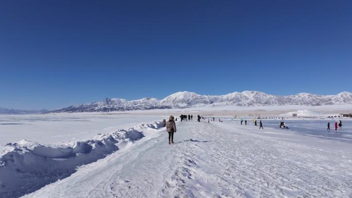 女孩在新疆赛里木湖白雪覆盖的湖面上行走