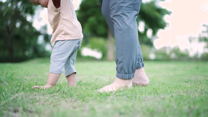 母亲训练儿子学会走路的第一步