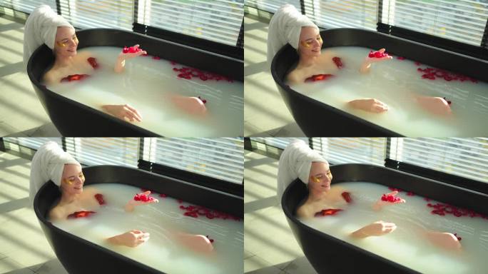 水疗中心放松。躺在浴室里的女人有红玫瑰花瓣。女孩在家里的浴室里放松。漂亮的女人喜欢洗热水澡。缓解压力