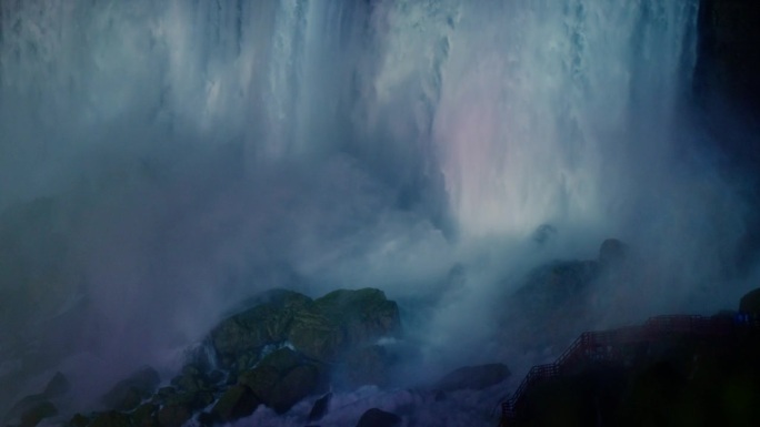 尼亚加拉大瀑布雄伟的水流反射出彩虹般的光芒。水冲击着下面的岩石。