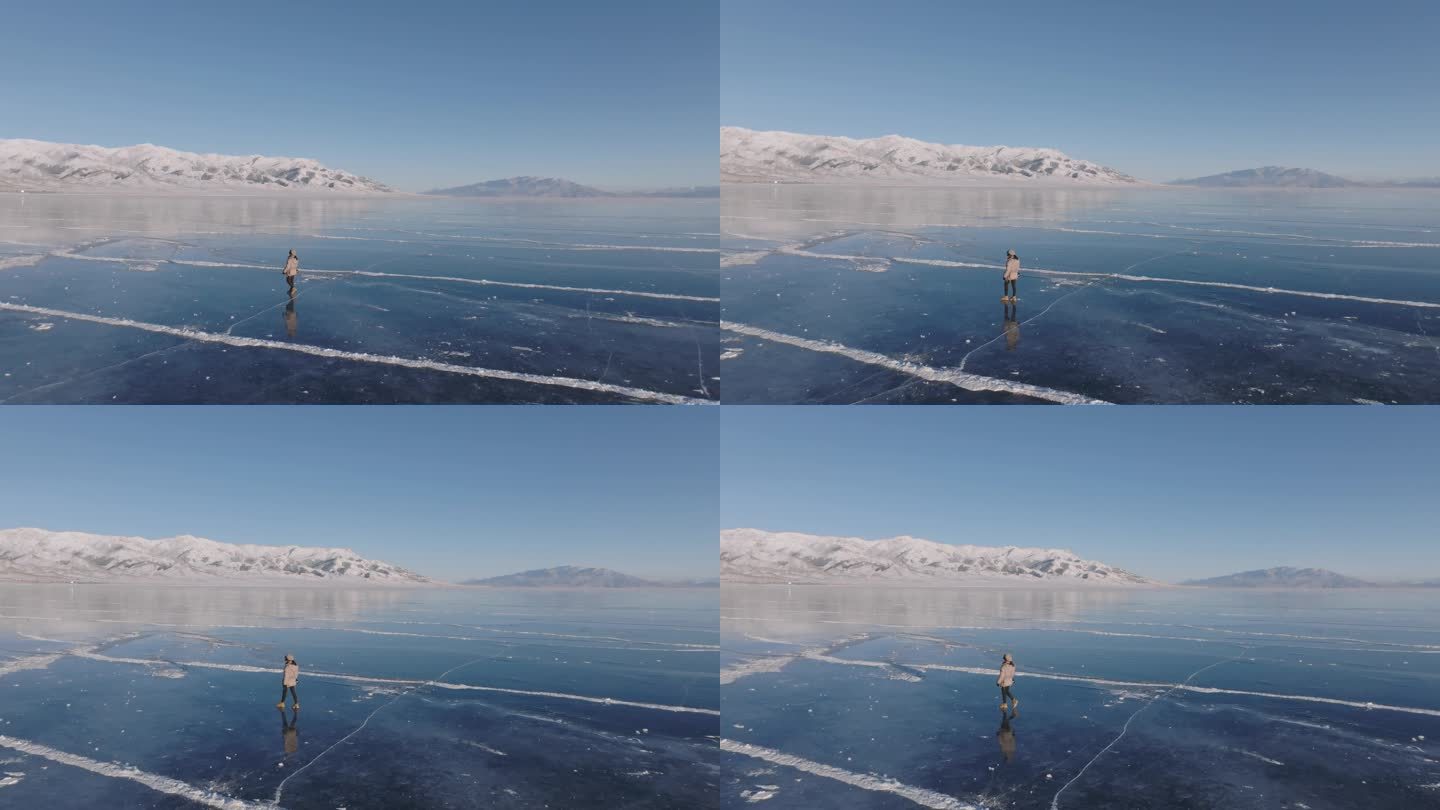 航拍女孩在新疆赛里木湖冰封蓝色湖面上行走