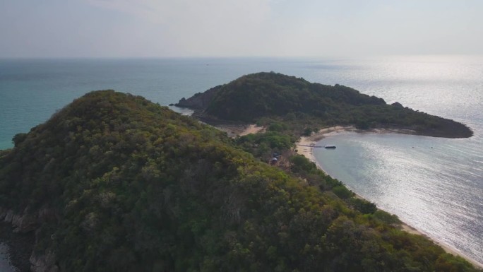 鸟瞰岛上原始的海岸线，碧绿的海水温柔地亲吻沙滩。这张迷人的照片捕捉到了海滨天堂的宁静和自然之美，郁郁