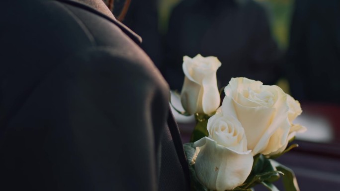 葬礼上拿着白玫瑰的无名女士