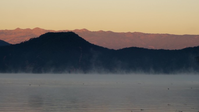 湖面雾气阳光山脉光影