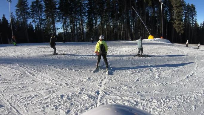 年轻女子第一次滑雪，后视图