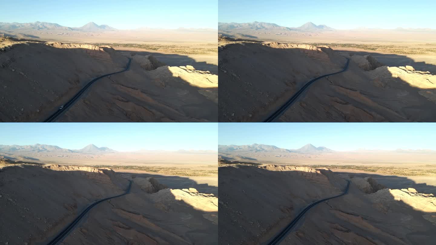 一架无人机优雅地飞过利坎卡布尔火山的干旱景观，露出了阿塔卡马的高速公路。捕捉充满活力的沙漠和旅行的精