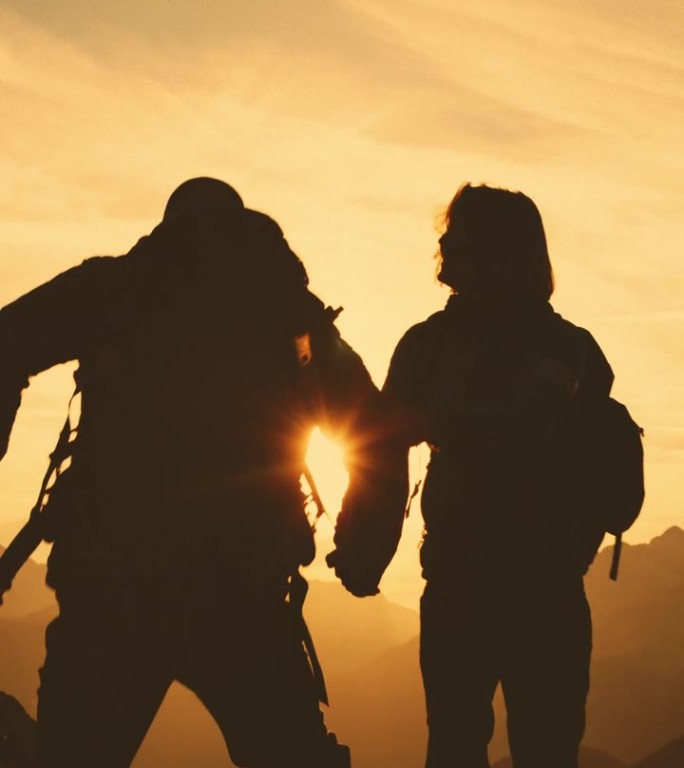 SLO MO拥抱高峰:一对夫妇在日落时分的山间小径上表达衷心支持的剪影