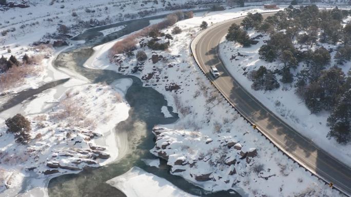 清晨白雪皑皑的冬日河景，从上面沿着道路或高速公路