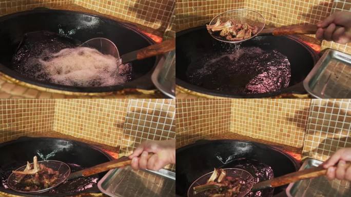 厨师用漏勺把肉块从锅里沸腾的油里捞出来