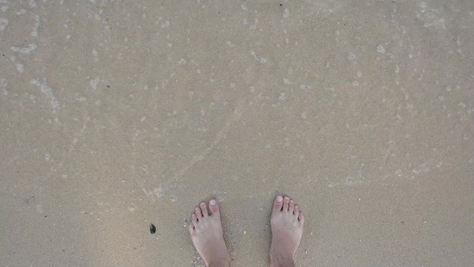 慢动作场景，近距离拍摄赤脚在夏季海上旅行的沙滩上