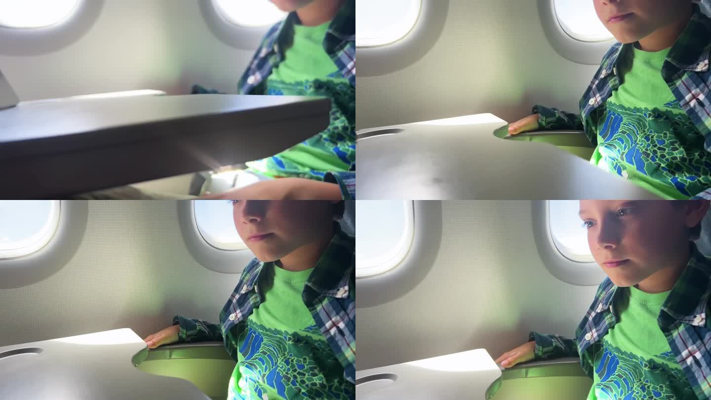 坐飞机旅行的白人男孩在平板电脑上看视频