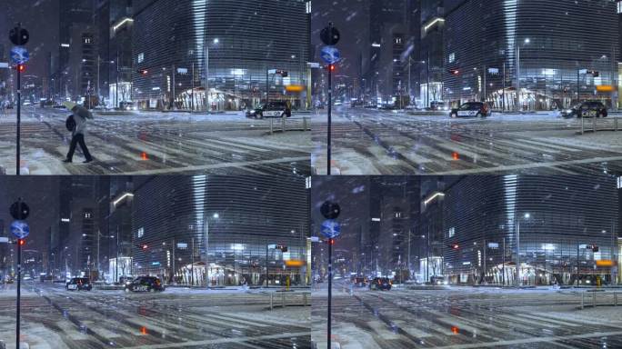 夜晚，东京的摩天大楼上飘着雪花，行人打着伞走着，汽车在东京站的雪道上驶过