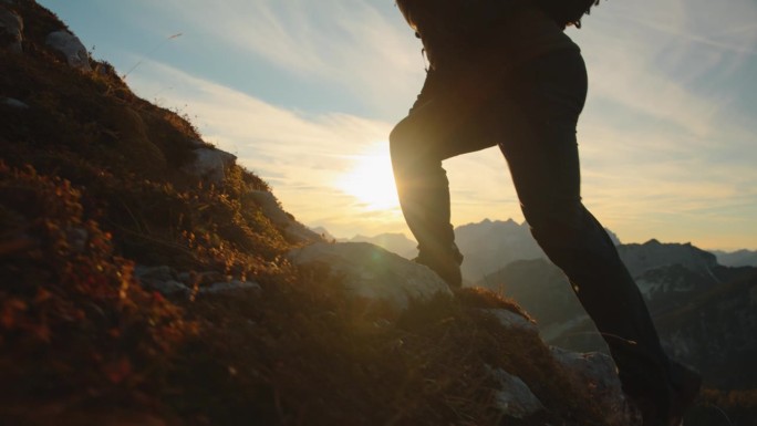 SLO MO高峰冲刺:冒险的徒步旅行者在长满草的山坡上赛跑