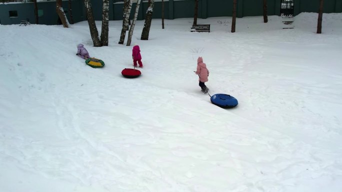 三胞胎小姐妹在冬天拿着充气芝士蛋糕爬雪山