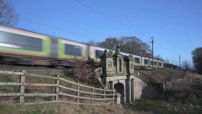 英国斯塔福德郡科尔维奇——2024年1月26日:一列客运列车驶过西海岸干线铁路上的一座铁路桥。