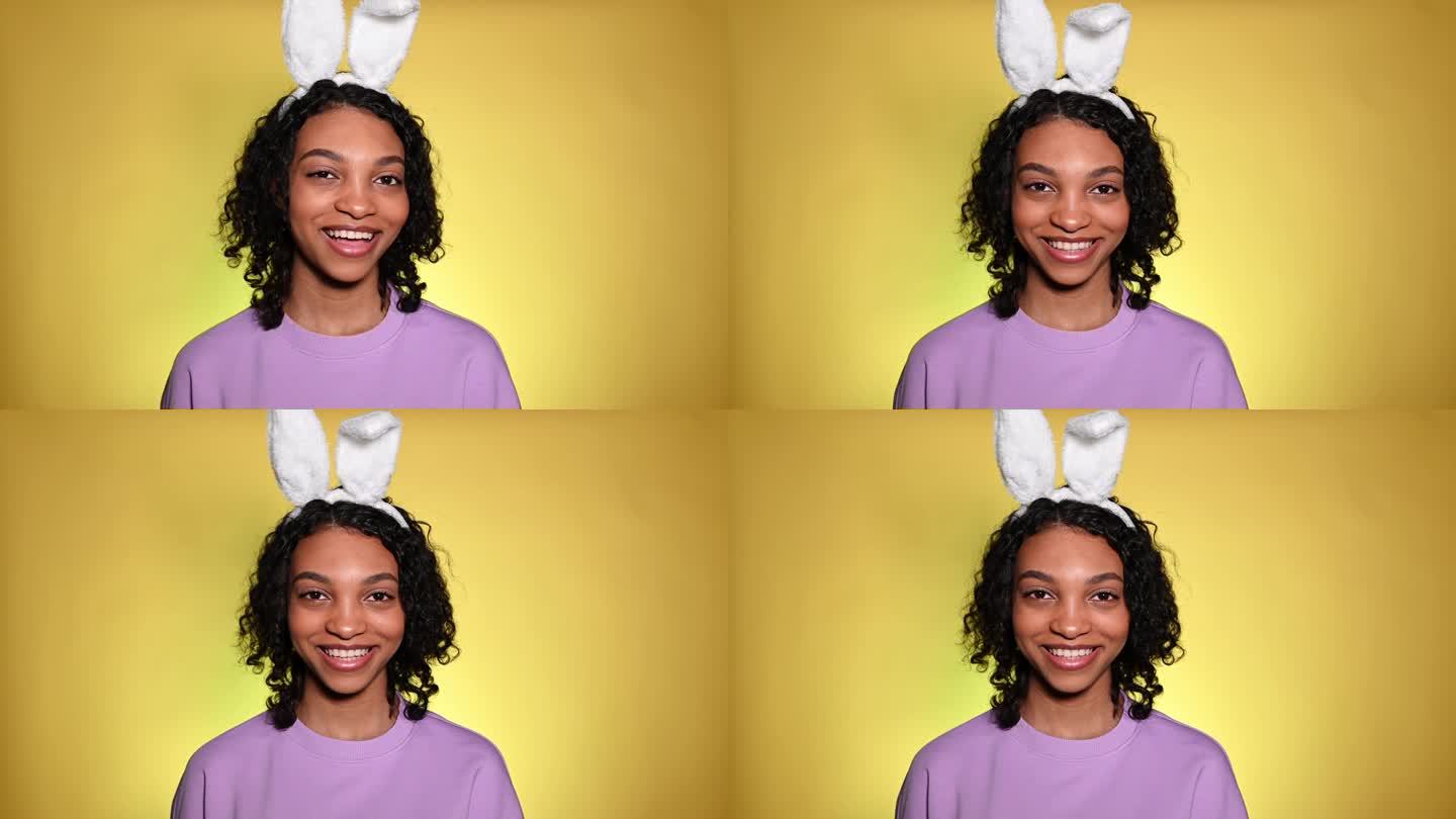 复活节摄影棚里可爱的女孩戴着兔子耳朵在眨眼。广告和促销理念