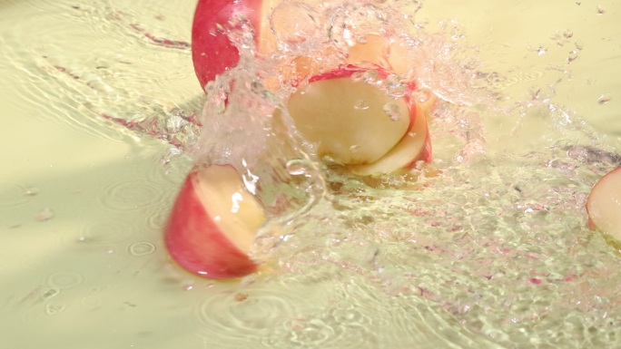 被切开的苹果在水面发生碰撞激起水花升格