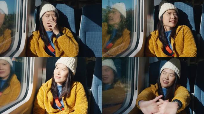 亚洲女游客早上在火车、城际公共交通上醒来，透过窗户向外看，很开心