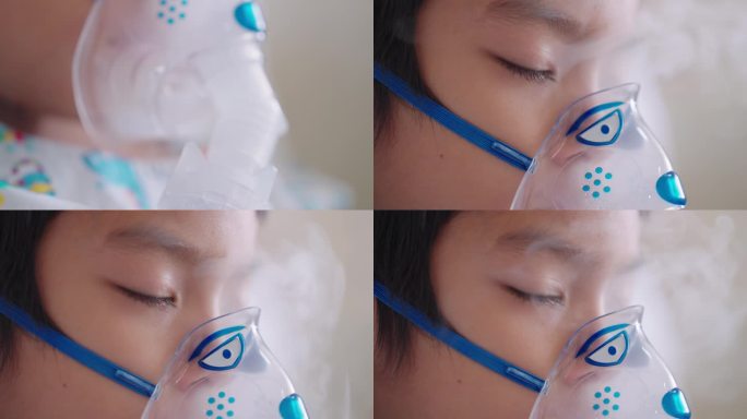 生病的亚洲男孩睡觉时戴着吸入器，面罩，侧视图近手持